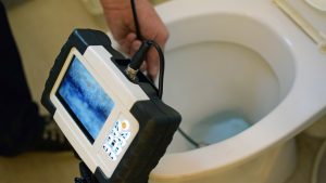 Checking clogged toilet pipe with inspection camera