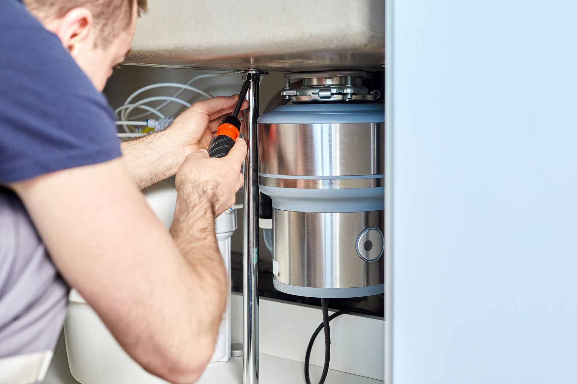 Plumber installing a new garbage disposal